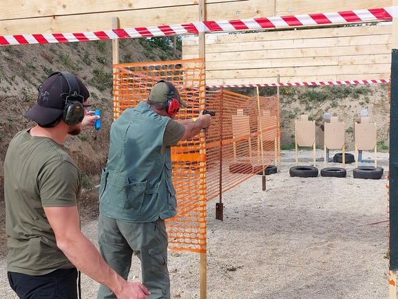 Muškarac puca iz pištolja iza barikade